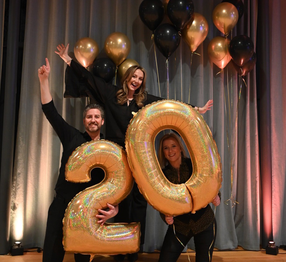 Tre personer står och firar 20 år
